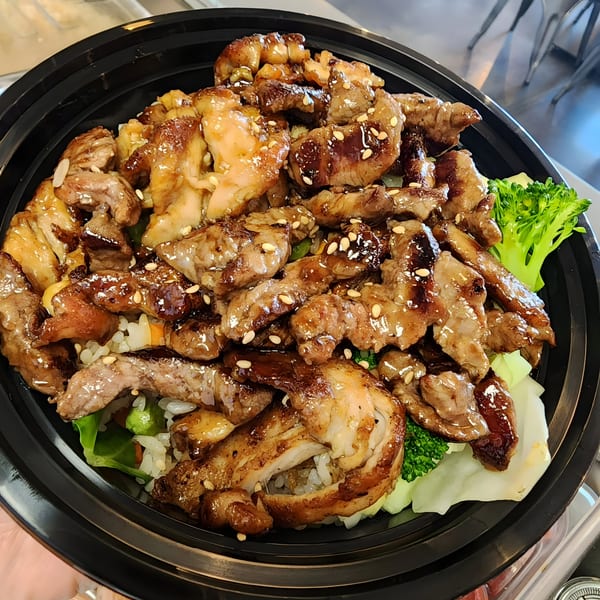 Teriyaki chicken and beef with sesame seeds, broccoli, and rice in a black bowl.